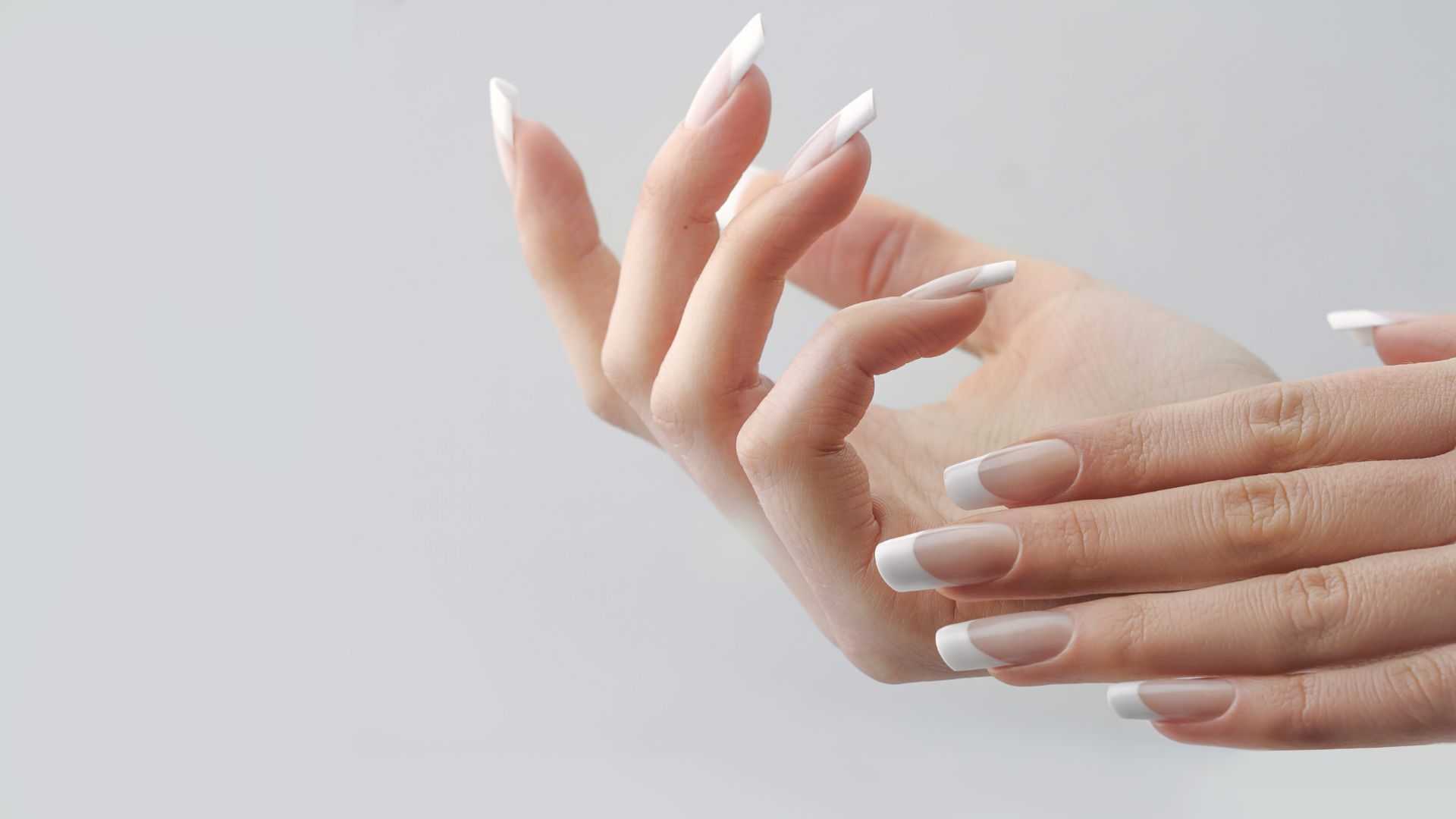 A close up of woman's hand with long nails - Hand Rejuvenation Treatments in Dubai